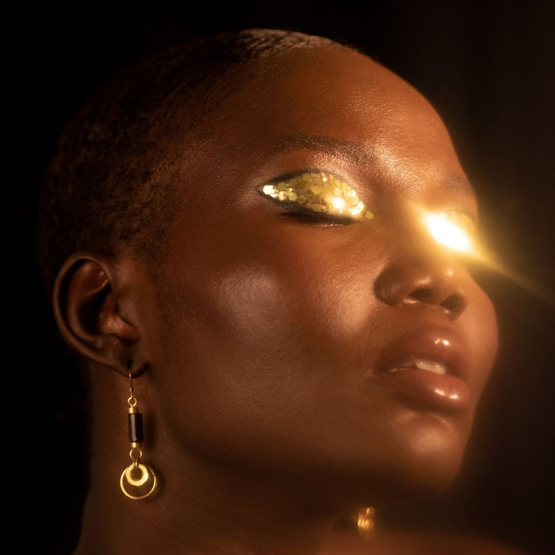 MONOXIDE earrings in a gold-lit editorial portrait